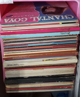 une pile de livres sur une étagère rose près d'une fenêtre