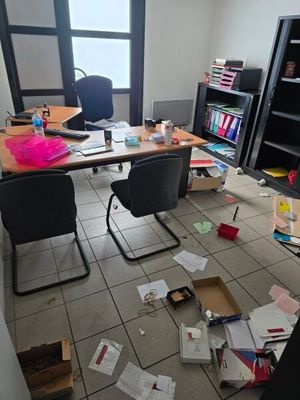 a messy office with a lot of clutter on the floor