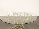 an image of a glass table with a metal base and a circular glass top