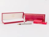une boîte ouverte contenant un stylo et un crayon, posée sur une surface blanche
