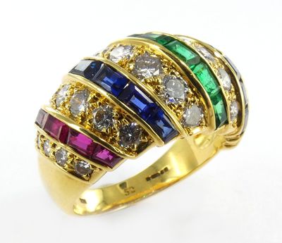 gros plan d'une bague en or avec des pierres multicolores