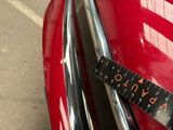 a measuring tape on the front of a red car