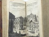 an open book with a drawing of a town on it