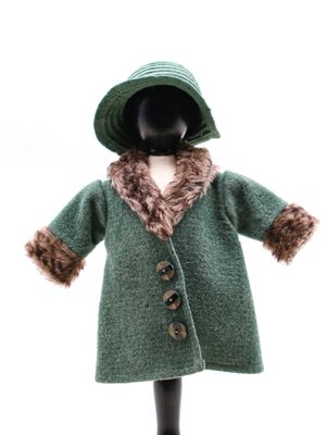 poupée portant un manteau vert et un chapeau muni d'une capuche doublée de fourrure