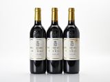 three bottles of wine sit on a white surface