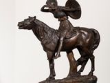 une statue représentant un homme à cheval, posée sur un socle