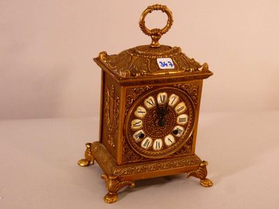 une horloge en or avec des chiffres romains sur le cadran