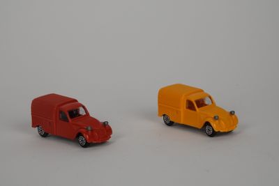 deux petites voitures posées côte à côte sur une surface blanche