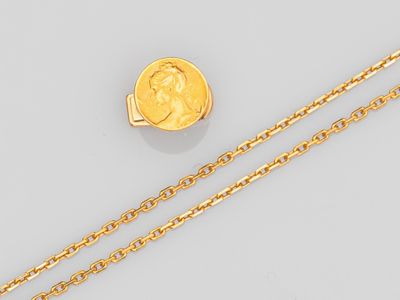 une pièce d'or et une chaîne sur un fond blanc
