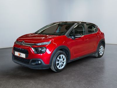 the red car is parked in a white room with a black floor