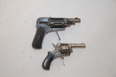 two revolvers that are on a white surface