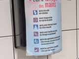 a sign hanging on the wall of a public restroom