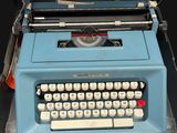 a blue typewriter sitting on top of a black table