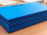 plusieurs chemises bleues empilées les unes sur les autres sur un bureau