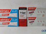 three boxes of elmex dentpaste sitting on a table