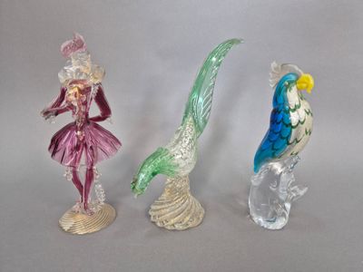 trois figurines en verre représentant une femme et un oiseau, posées sur un socle