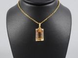 un collier plaqué or avec un pendentif en verre de forme carrée, monté sur une chaîne en or