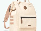 a white backpack with a tan leather handle and tan straps