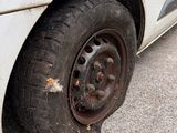 a dirty tire on the side of a white car