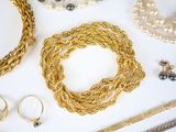 many different types of jewelry laid out on a white surface