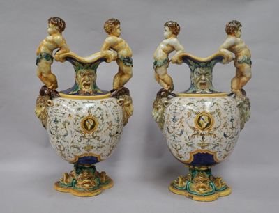 une paire de vases anciens ornés de personnages, posés sur une table