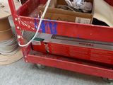 a red cart that has a bunch of boxes in it