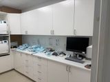 a white kitchen with white cabinets and a computer on the counter