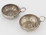 une paire de tasses en argent munies d'anses et de poignées