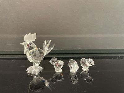 une figurine en verre représentant un oiseau et trois petits oiseaux