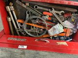 a red tool box full of tools on the floor