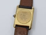 a gold watch on a brown leather strap