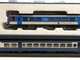 un train bleu et blanc dans une boîte posée sur une surface blanche