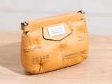 leather pouch with map print on it sitting on a wooden table