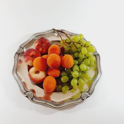 a plate of fruit on a table with a white background