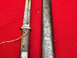 two old knives are laying on a red surface
