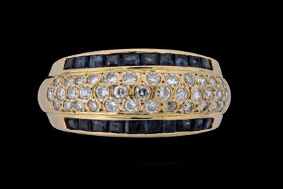un gros plan d'une bague sertie d'un diamant et d'un saphir sur fond noir