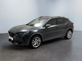 Une voiture grise est garée dans une pièce au sol noir.