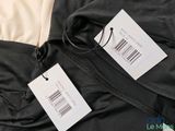 the back of a black jacket with a price tag attached to it