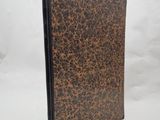 a brown and black book with a brown cover on a white background