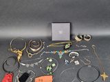 a group of assorted jewelry including bracelets, rings, and necklaces