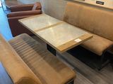 un banc et une table dans une pièce où sont accrochés des tableaux au mur
