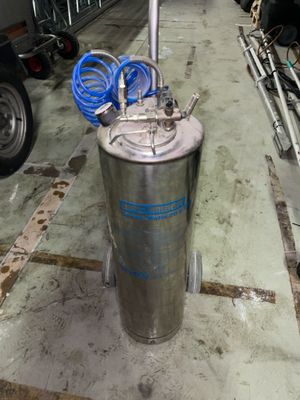 a metal tank with a blue handle on the floor