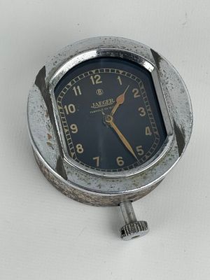 une horloge argentée avec un cadran noir sur un fond blanc