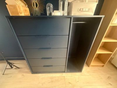 a black dresser in the corner of a room