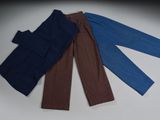 trois paires de pantalons posées les unes sur les autres sur une table