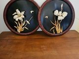 pair of black and white flowers in a wooden frame on a wooden table