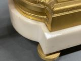 a gold and white clock sitting on top of a table
