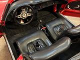 a red sports car with a black leather seat in the back