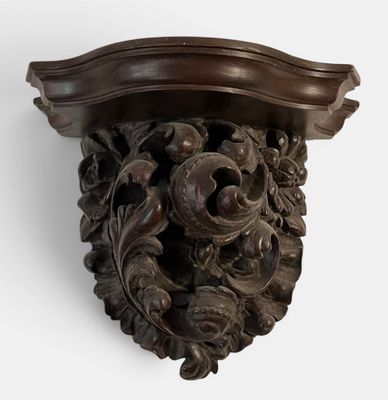 a carved wood shelf with a decorative design on it
