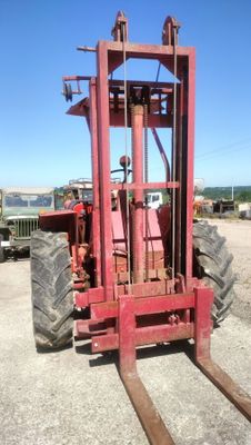 un chariot élévateur rouge garé sur le bord de la route